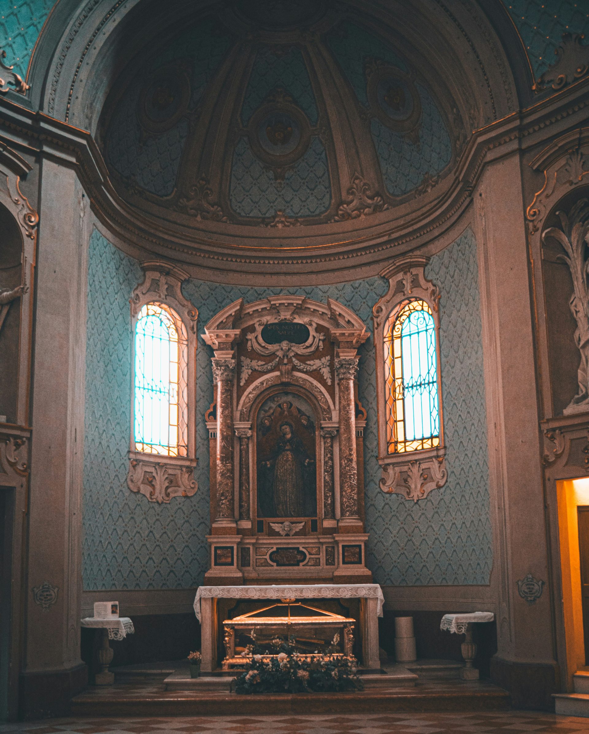 a church with a large alter and stained glass windows